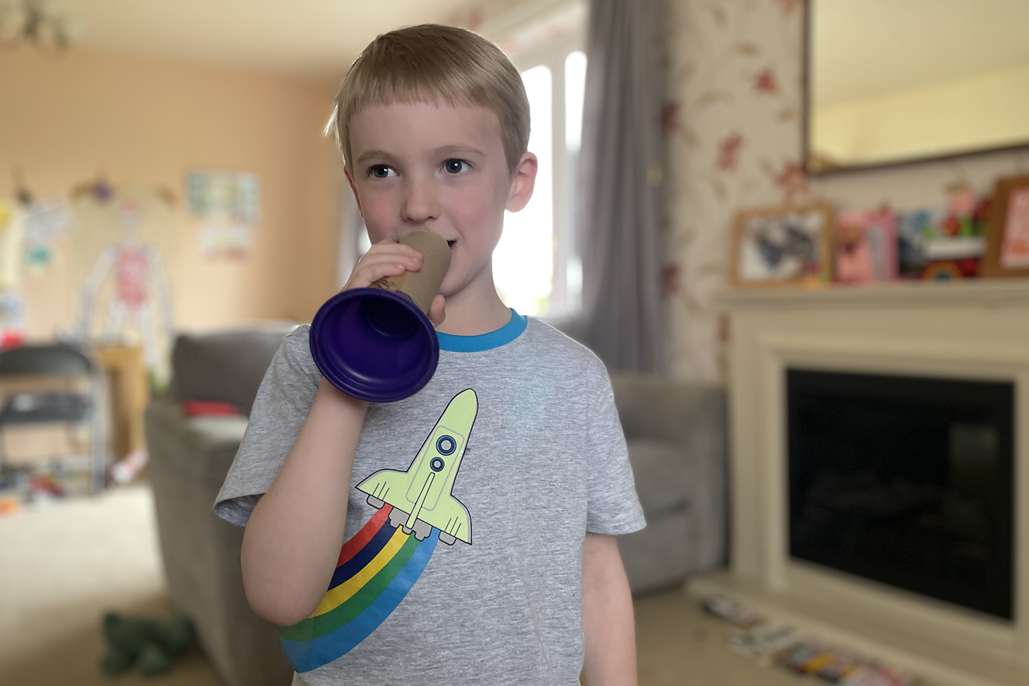 Gabe holding a toilet roll tube megaphone in front of his mouth