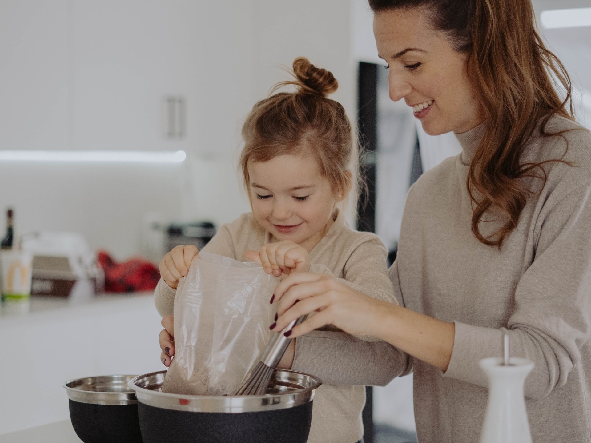 mother and young daughter baking together