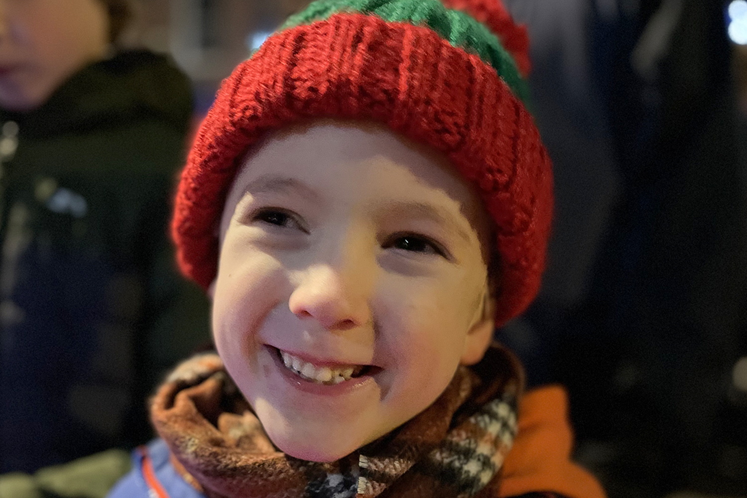 Gabe wearing a red and green bobble hat smiling close to the camera