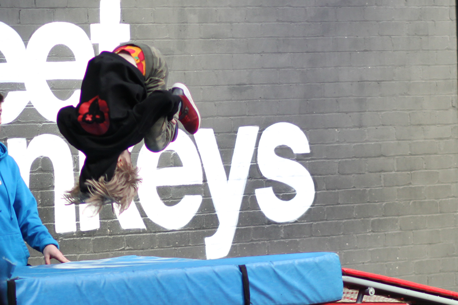 Toby spinning upside down over a crash mat, mid front flip